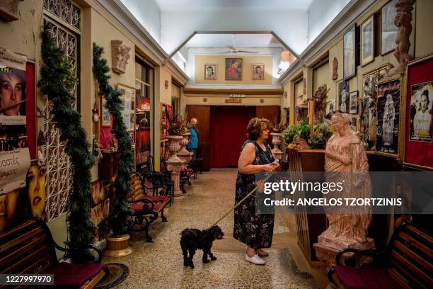 Greek spectator buys a ticket for a film at the open-air cinema "Oasis" in Athens on August 1, 2020. - Real institutions of the Athenian summer, the...