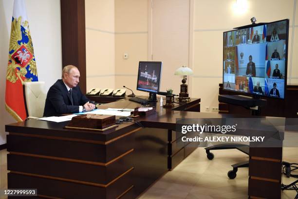 Russian President Vladimir Putin chairs a meeting with members of the government via a teleconference call at the Novo-Ogaryovo state residence...