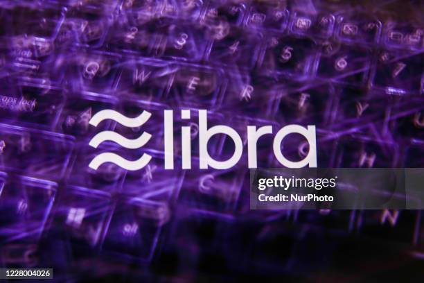 Logo of Libra digital currency displayed on a phone screen and a keyboard are seen in this multiple exposure illustration photo taken in Krakow,...