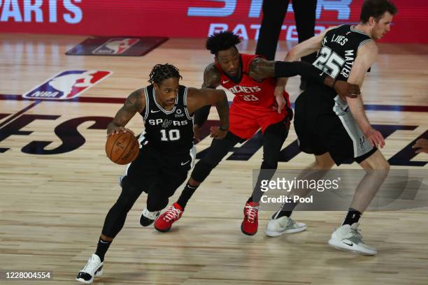 DeMar DeRozan of the San Antonio Spurs drives past Robert Covington of the Houston Rockets off a screen by Jakob Poeltl of the San Antonio Spurs...