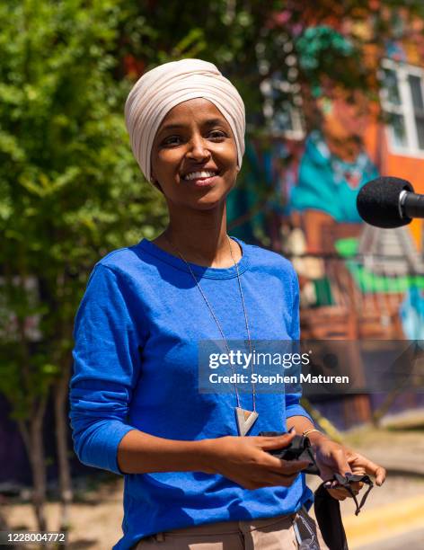 Rep. Ilhan Omar removes her mask to speak with media gathered outside Mercado Central on August 11, 2020 in Minneapolis, Minnesota. Omar is hoping to...