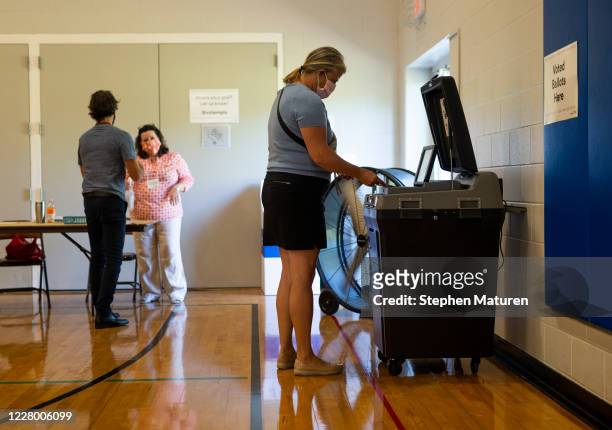 Voter submits their ballot at a polling place in the Pearl Park Recreation Center on August 11, 2020 in Minneapolis, Minnesota. Amongst other...