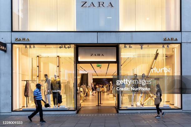 Shoppers in protective face masks are seen passing ZARA shop at Oxford Street as Coronavirus lockdown eases in London, England, United Kingdomon,...