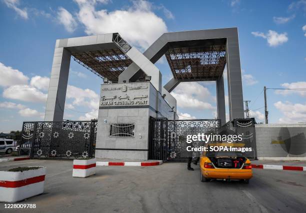 Members of the Palestinian Hamas security forces wearing protective masks are seen checking passengers before allowing them through the Rafah land...