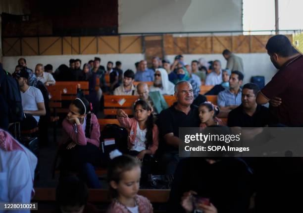 Palestinians wait with their families to cross to the Egyptian side of Rafah border crossing. Egypt reopens the Rafah land crossing after months of...