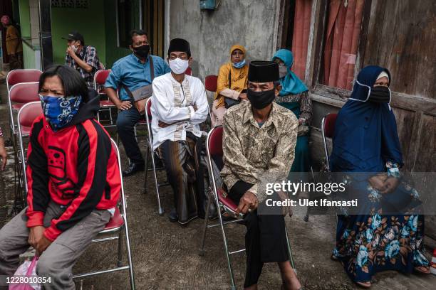 Grooms and Brides family wearing protective masks attend a mass wedding ceremony to commemorate the 75th Indonesia's National Independence Day at...