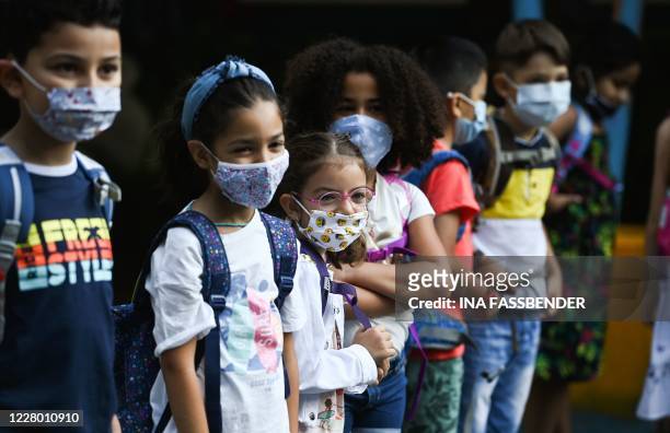 Students with face masks line up on the schoolyard of the Petri primary school in Dortmund, western Germany, on August 12 amid the novel coronavirus...