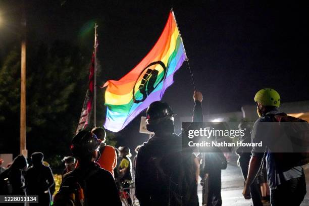 Protesters chant and wave flags in front of the Multnomah County Sheriff's Office on August 11, 2020 in Portland, Oregon. A small crowd gathered...