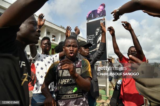 Fans of Ivory Coast's "coupé-décalé" music star DJ Arafat gesture in Abidjan on August 12 as they gather to commemorate the one year mark after the...