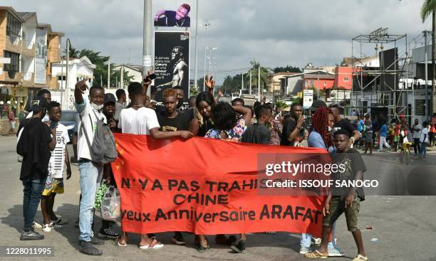 Fans of Ivory Coast's "coupé-décalé" music star DJ Arafat gesture in Abidjan on August 12 as they gather to commemorate the one year mark after the...