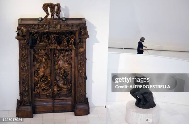 Worker wears a face mask at the Soumaya Museum in Mexico City on August 12, 2020 as museums, cinemas and pools are reopening in Mexico as part of the...