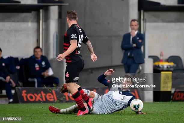 Western Sydney Wanderers midfielder Simon Cox is tackled by Melbourne Victory forward Nils Ola Toivonen during the round 27 A-League soccer match...