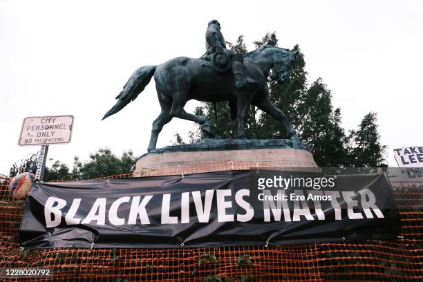 The statue of Robert E Lee with a banner that reads "Black Lives Matter" during the "Reclaim the Park" gathering at Emancipation Park on August 12,...