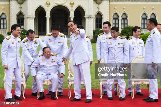 Thai Prime Minister Prayut Chan-o-cha assists his Deputy Prime Minister General Prawit Wongsuwan during a group photo after cabinet reshuffle at...