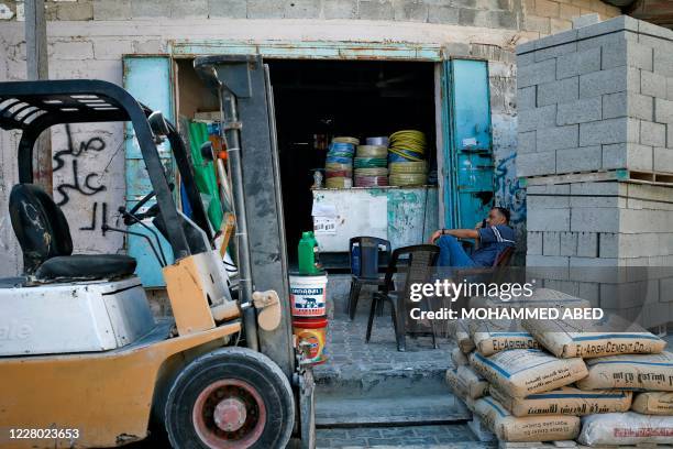 Palestinian owner displays materials used for construction purpose outside his shop in Gaza City on August 13, 2020. - Israel attacked Hamas targets...