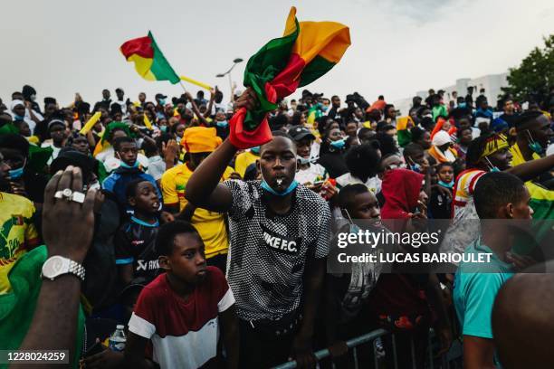 In this photograph taken on August 12 Malian team supporters react after a goal as a "Mali" team and a "Rest of the World" team compete during the...