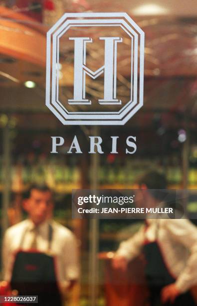 Deux employés de la société Hediard, fondée en 1854 et située Avenue Georges V à Paris, attendent des clients derrière la porte de l'épicerie fine ou...