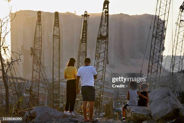 Couple and children contemplate the damage in front of the grain silo at the port of Beirut on August 13 more than a week after a massive blast...