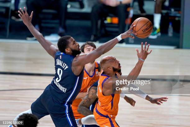 Michael Kidd-Gilchrist of the Dallas Mavericks knocks the ball away from Jevon Carter of the Phoenix Suns during the second half at AdventHealth...