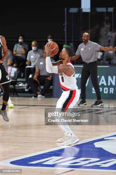 Damian Lillard of the Portland Trail Blazers shoots a three point basket from the NBA logo and makes it during he game against the Brooklyn Nets on...