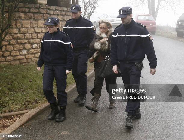 Des gendarmes escortent le 10 janvier 2008 à Charnay un membre de la famille de Romaric, un enfant de deux ans et demi qui a été dévoré la veille par...