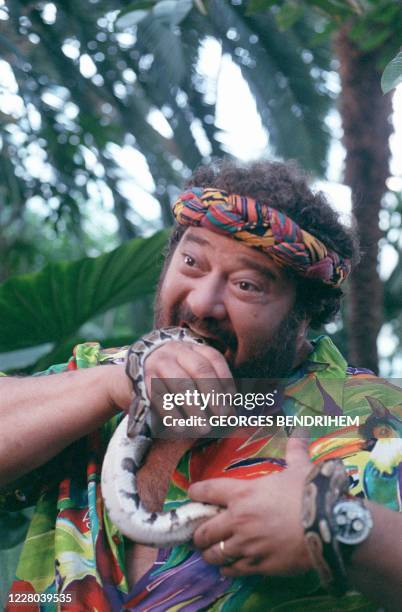 Le chanteur Carlos partifait mine de manger un serpent pendant l'émission de TF1 "Sirocco" dans la serre d'Auteuil le 15 octobre 1988. Le chanteur...