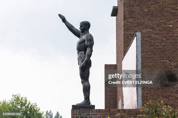 Picture taken on August 14, 2020 shows the statue of an athlete with his right arm raised by Dutch sculptor Gra Rueb from 1928 in front of the...