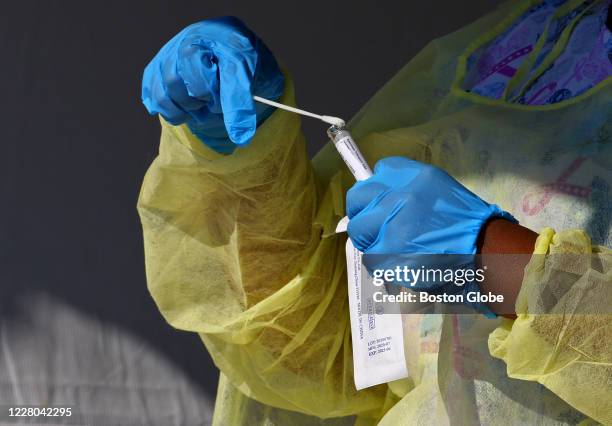 Registered nurses put Covid-19 test samples in vials at the Joe Moakley Park during the pop-up free COVID-19 testing by registered nurses from the...
