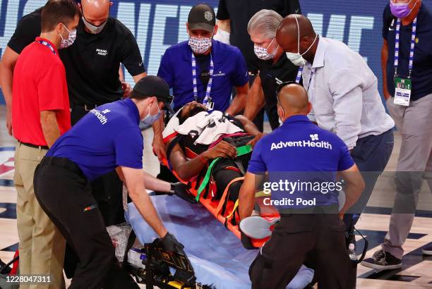 Derrick Jones Jr. #5 of the Miami Heat is tended to by medical personnel after colliding with Goga Bitadze of the Indiana Pacers during the second...