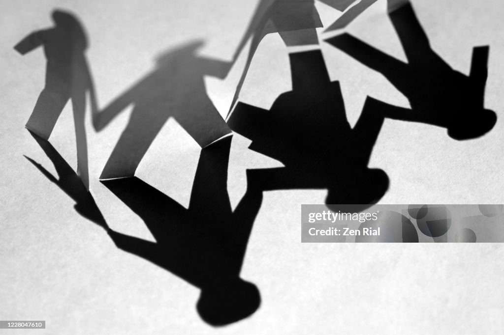 Paper cut out and it's shadow depicting a family of four