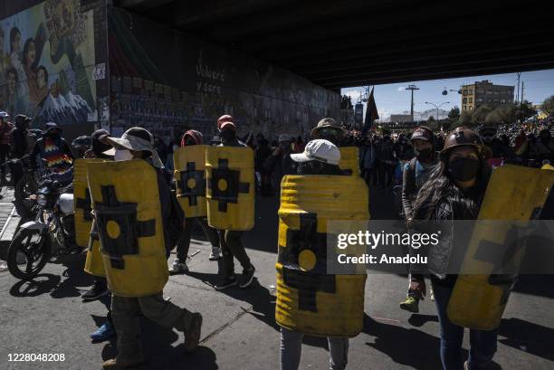 Demonstrators holding metal shields are seen during a massive protest against the renewed postponement of presidential elections and to demand the...