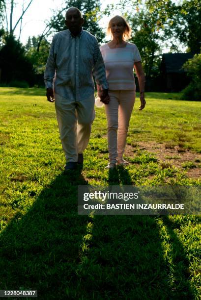 Daniel Smith and his wife Loretta Neumann walk in the backyard of their home in Northwest Washington during an interview with AFP on August 5 in...