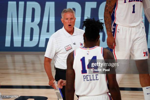 Head coach Brett Brown of the Philadelphia 76ers talks with Norvel Pelle during a timeout in the first half against the Houston Rockets at...