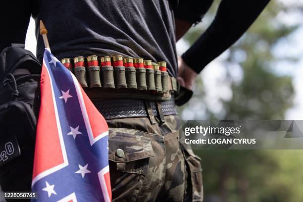 Man with ammunition can be seen in front of a confederate flag as members of far right militias and white pride organizations rally near Stone...