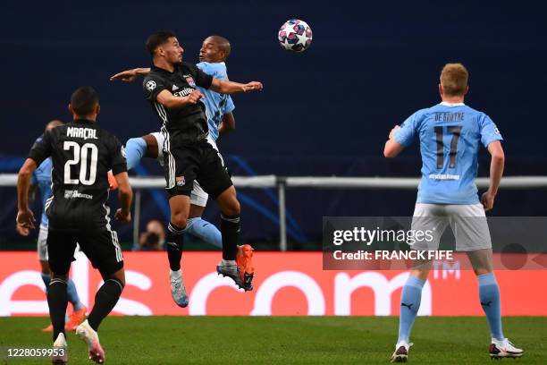 Lyon's French midfielder Houssem Aouar and Manchester City's Brazilian midfielder Fernandinho jump to head the ball during the UEFA Champions League...