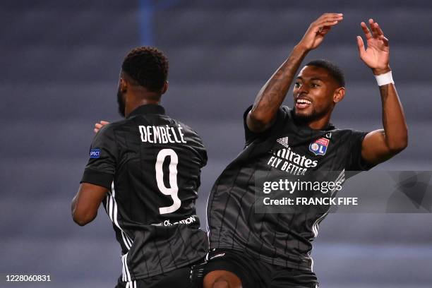 Lyon's French forward Moussa Dembele celebrates with Lyon's French midfielder Jeff Reine-Adelaide after scoring his second goal during the UEFA...
