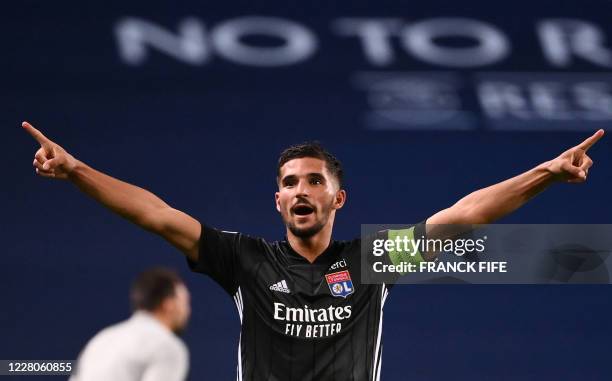 Lyon's French midfielder Houssem Aouar celebrates their win at the end of the UEFA Champions League quarter-final football match between Manchester...
