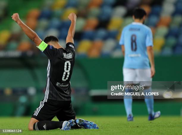 Lyon's French midfielder Houssem Aouar celebrates his team's win at the end of the UEFA Champions League quarter-final football match between...