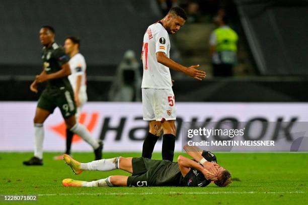 Sevilla's Moroccan forward Youssef En-Nesyri gstures to Manchester United's English defender Brandon Williams to get up during the UEFA Europa League...