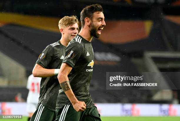 Manchester United's Portuguese midfielder Bruno Fernandes celebrates scoring the opening goal with his teammate Manchester United's English defender...