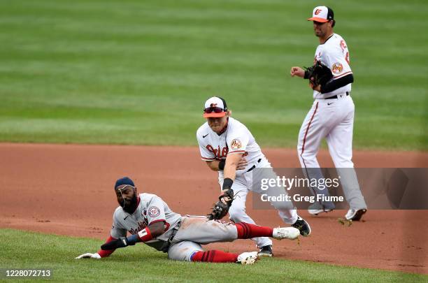 Josh Harrison of the Washington Nationals is tagged out in the fourth inning by Pat Valaika of the Baltimore Orioles at Oriole Park at Camden Yards...
