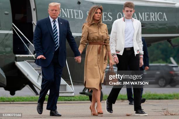 President Donald Trump walks with First Lady Melania Trump and their son Barron as they arrive at Morristown Municipal Airport in Morristown, New...