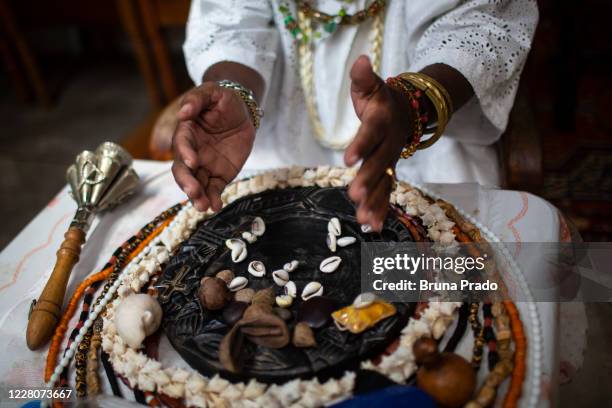 Babalorixá Valmiro dos Santos, known as Pai Miro Ijitade consults the Orixás through Cowrie shells readings in the Templo de Candombe Terreiro Ilê...