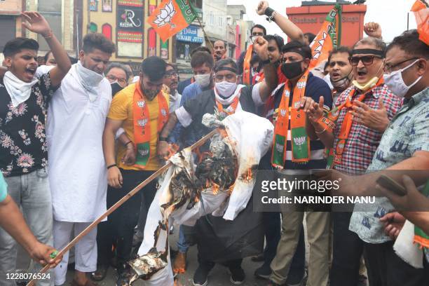Bharatiya Janata Party activists shout slogans as they burn an effigy of Punjab Chief Minister Amarinder Singh during a protest against Punjab...