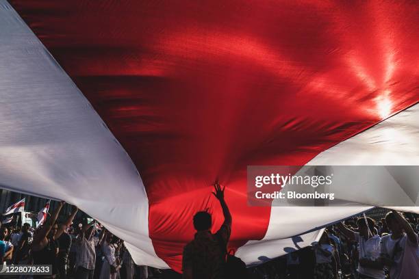 Protesters unfurl a banner in the colors of the former Belarus national flag as they call for the resignation of President Alexander Lukashenko in...