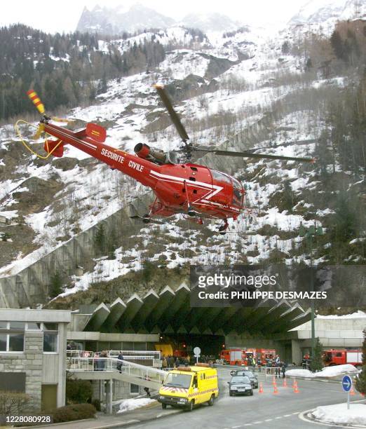 Un hélicoptère de la Sécurité civile décolle, le 25 mars 1999 devant l'entrée du tunnel du Mont-Blanc, où un incendie s'est déclaré la veille faisant...