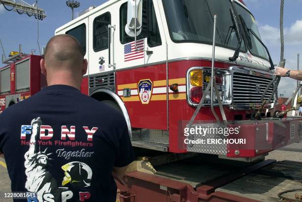 Un sapeur pompier de la Brigade des Sapeurs Pompiers de Paris assiste au déchargement de l'"American-LaFrance", un camion incendie du Fire Department...