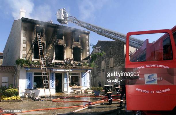 Des pompiers interviennent, le 01 juillet 2001 à Coulon, sur l'incendie d'une maison au cours duquel une fillette de 3 et un garçon de 5 ans sont...
