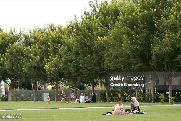 People picnic in the grass at Klyde Warren Park in downtown Dallas, Texas, U.S., on Monday, Aug. 17, 2020. Texas officials have launched an...