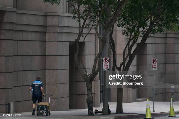 An Amazon delivery person pushes a cart of packages through downtown Dallas, Texas, U.S., on Monday, Aug. 17, 2020. Texas officials have launched an...